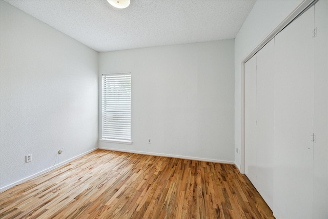 1100 Augusta Dr Unit 63, Houston, TX 77057 - unfurnished bedroom with wood finished floors, a closet, and a textured ceiling