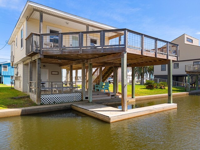 16711 Kingston Way, Galveston, TX 77554 - back of property with stairway, a deck with water view, and a lawn