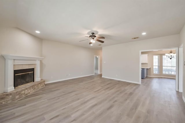 615 Rosewood Pl, Joshua, TX 76058 - unfurnished living room with a ceiling fan, a tile fireplace, a chandelier, light wood finished floors, and recessed lighting