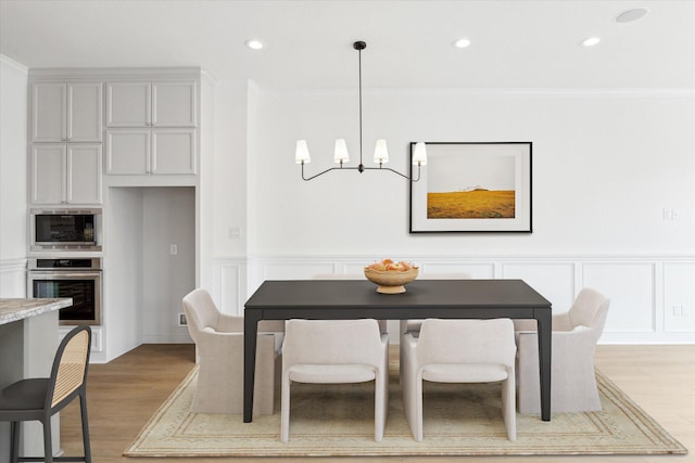 306 Felt Cir, Houston, TX 77011 - dining area with a chandelier, light wood-style flooring, recessed lighting, a decorative wall, and ornamental molding