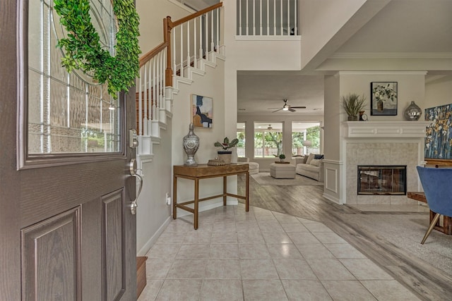 22811 Northampton Pines Dr, Spring, TX 77389 - foyer entrance with a tile fireplace, crown molding, a ceiling fan, a high ceiling, and stairs