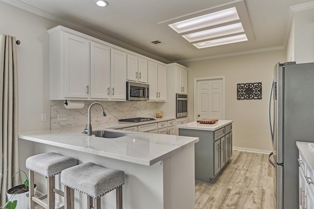 22811 Northampton Pines Dr, Spring, TX 77389 - kitchen featuring appliances with stainless steel finishes, a center island, light stone counters, ornamental molding, and backsplash