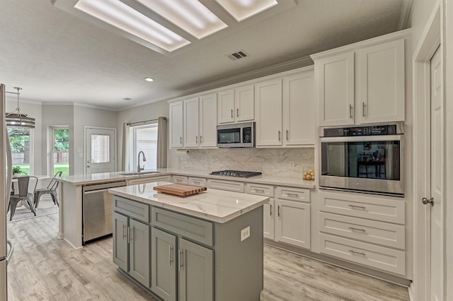 22811 Northampton Pines Dr, Spring, TX 77389 - kitchen with stainless steel appliances, white cabinetry, a peninsula, ornamental molding, and gray cabinetry