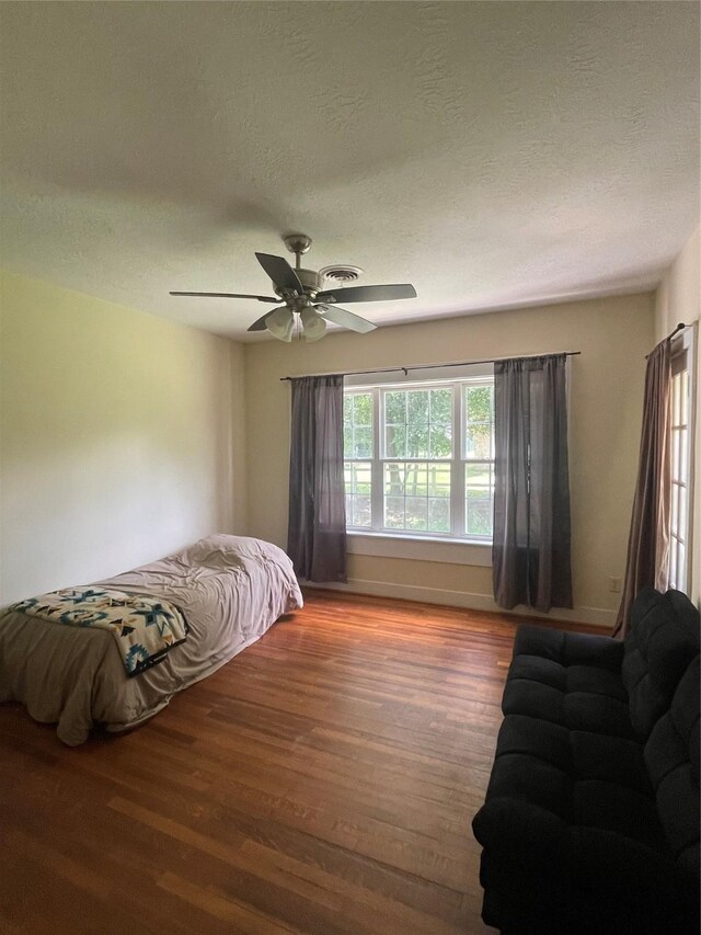 926 S Cass St, Centerville, TX 75833 - bedroom featuring wood finished floors, a textured ceiling, and ceiling fan
