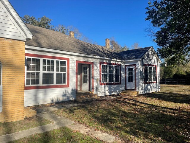 926 S Cass St, Centerville, TX 75833 - view of front of property featuring a chimney, a front yard, entry steps, brick siding, and roof with shingles