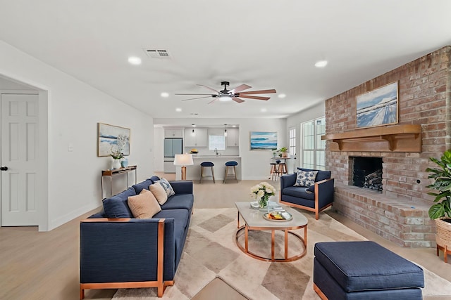 8215 Twining Oaks Ln, Spring, TX 77379 - living room with ceiling fan, recessed lighting, a brick fireplace, and light wood-style flooring