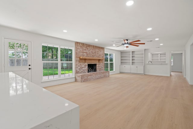 8215 Twining Oaks Ln, Spring, TX 77379 - unfurnished living room with recessed lighting, a ceiling fan, a fireplace, light wood-style floors, and built in shelves