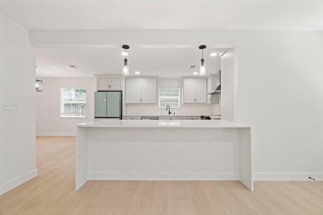 8215 Twining Oaks Ln, Spring, TX 77379 - kitchen with freestanding refrigerator, light wood finished floors, light countertops, decorative backsplash, and plenty of natural light