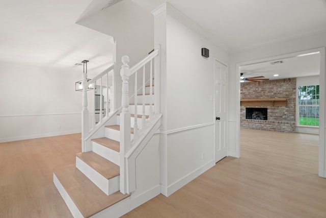 8215 Twining Oaks Ln, Spring, TX 77379 - stairs with wood finished floors, a ceiling fan, a fireplace, and crown molding