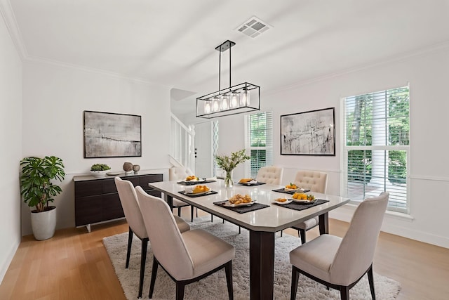 8215 Twining Oaks Ln, Spring, TX 77379 - dining area featuring crown molding, light wood finished floors, and a chandelier