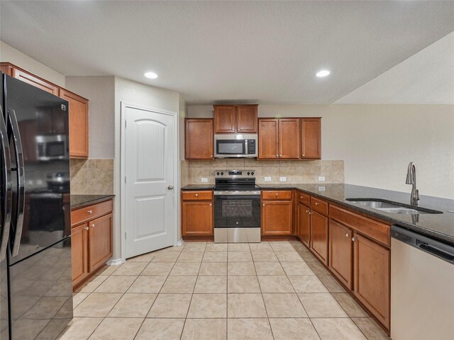 419 Eastern Phoebe, San Antonio, TX 78253 - kitchen featuring appliances with stainless steel finishes, brown cabinets, tasteful backsplash, dark stone countertops, and recessed lighting