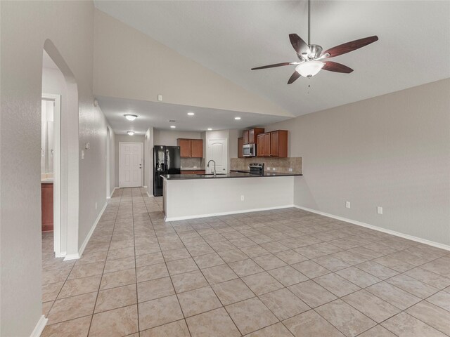 419 Eastern Phoebe, San Antonio, TX 78253 - kitchen with dark countertops, stainless steel microwave, ceiling fan, black fridge, and vaulted ceiling