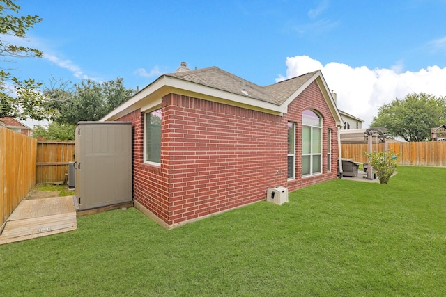 18114 Rustic Springs Dr, Tomball, TX 77375 - view of side of property featuring a fenced backyard, brick siding, roof with shingles, a shed, and a chimney