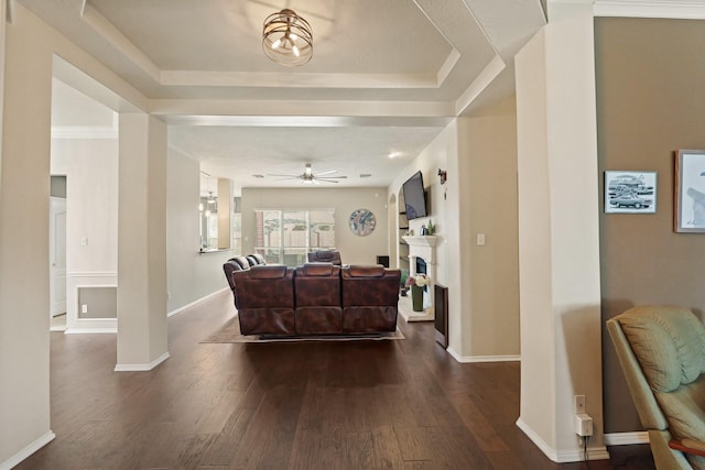 18114 Rustic Springs Dr, Tomball, TX 77375 - living area with ceiling fan, dark wood-style floors, a fireplace, and a tray ceiling