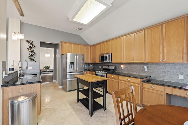 18114 Rustic Springs Dr, Tomball, TX 77375 - kitchen with appliances with stainless steel finishes, decorative backsplash, vaulted ceiling, light tile patterned floors, and dark stone counters