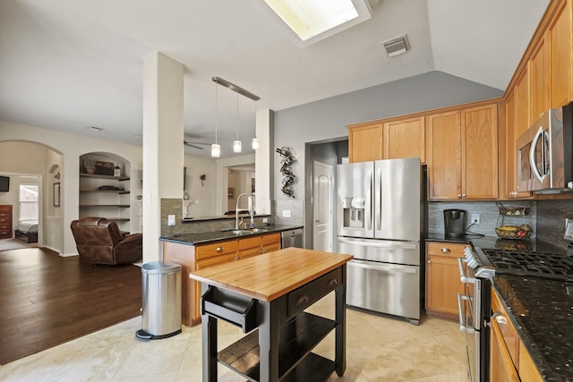 18114 Rustic Springs Dr, Tomball, TX 77375 - kitchen with stainless steel appliances, arched walkways, tasteful backsplash, and pendant lighting