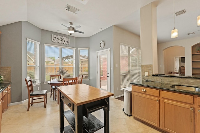 18114 Rustic Springs Dr, Tomball, TX 77375 - kitchen featuring a ceiling fan, decorative light fixtures, light tile patterned flooring, and dark stone countertops