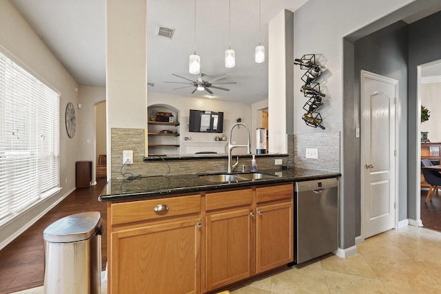 18114 Rustic Springs Dr, Tomball, TX 77375 - kitchen featuring stainless steel dishwasher, healthy amount of natural light, dark stone counters, and backsplash