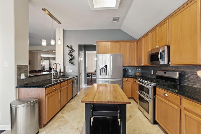 18114 Rustic Springs Dr, Tomball, TX 77375 - kitchen with stainless steel appliances, decorative backsplash, dark stone counters, vaulted ceiling, and hanging light fixtures