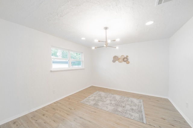 8318 Hanfro Ln, Houston, TX 77088 - spare room with a chandelier, wood finished floors, a textured ceiling, and recessed lighting