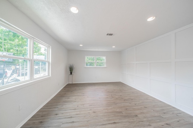 8318 Hanfro Ln, Houston, TX 77088 - empty room featuring a decorative wall, light wood-type flooring, and recessed lighting