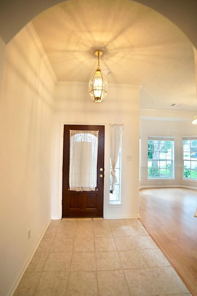 14811 Horse Creek Ln, Sugar Land, TX 77498 - tiled entrance foyer featuring arched walkways, ornamental molding, and a chandelier