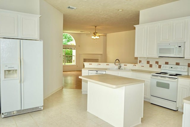 14811 Horse Creek Ln, Sugar Land, TX 77498 - kitchen featuring white appliances, light countertops, tasteful backsplash, a peninsula, and white cabinetry