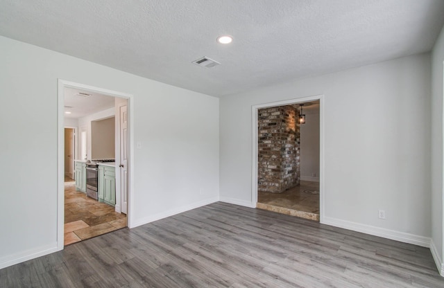 22710 Earlmist Dr, Spring, TX 77373 - empty room featuring wood finished floors, a textured ceiling, and recessed lighting