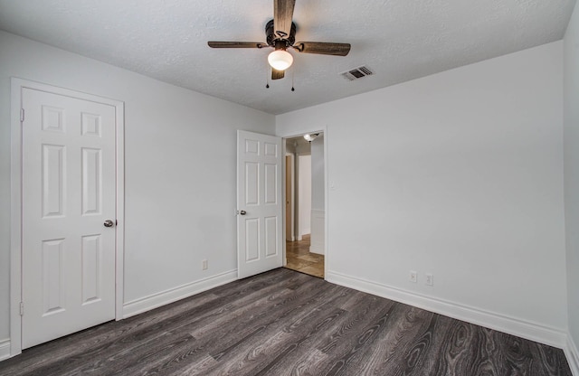 22710 Earlmist Dr, Spring, TX 77373 - unfurnished bedroom featuring dark wood-type flooring, a textured ceiling, and a ceiling fan