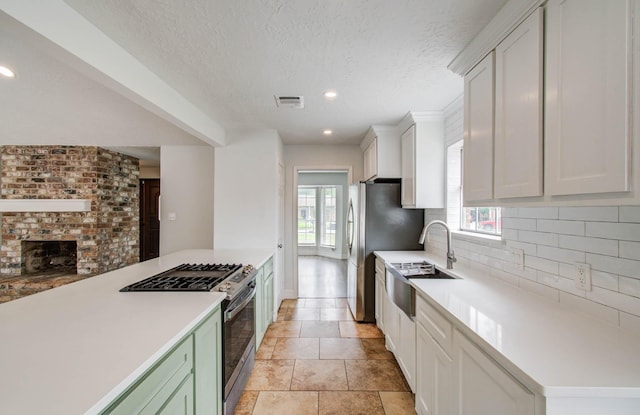 22710 Earlmist Dr, Spring, TX 77373 - kitchen featuring appliances with stainless steel finishes, backsplash, light countertops, white cabinets, and a textured ceiling
