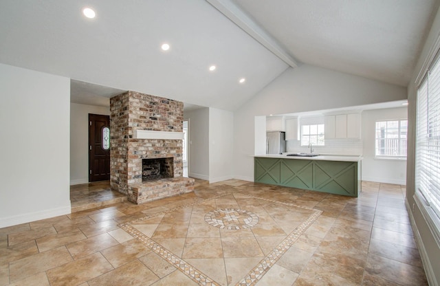 22710 Earlmist Dr, Spring, TX 77373 - unfurnished living room with beam ceiling, high vaulted ceiling, recessed lighting, and a brick fireplace