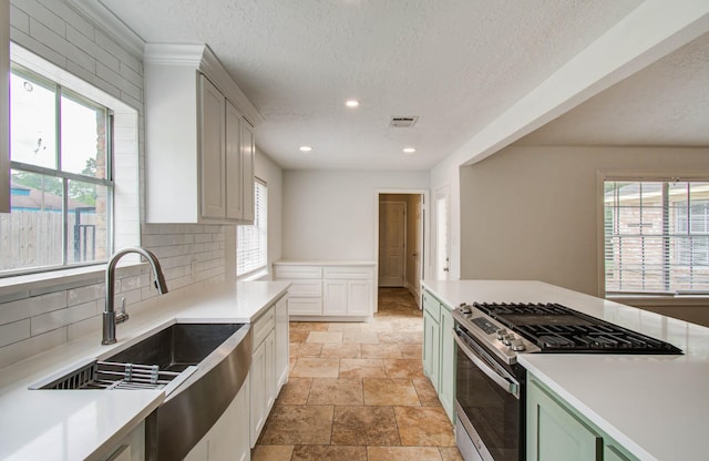 22710 Earlmist Dr, Spring, TX 77373 - kitchen with stainless steel gas range oven, healthy amount of natural light, a textured ceiling, tasteful backsplash, and recessed lighting
