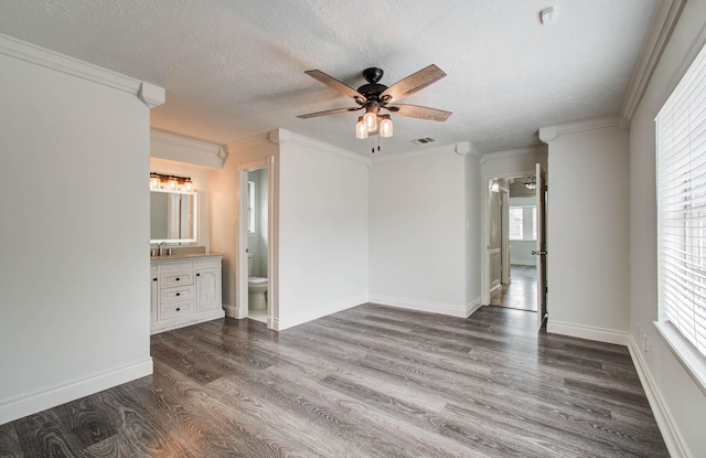 22710 Earlmist Dr, Spring, TX 77373 - empty room featuring dark wood-type flooring, a ceiling fan, healthy amount of natural light, a textured ceiling, and ornamental molding