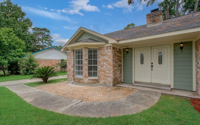 22710 Earlmist Dr, Spring, TX 77373 - doorway to property featuring a chimney, brick siding, and roof with shingles