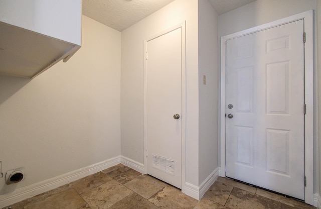 22710 Earlmist Dr, Spring, TX 77373 - laundry area with stone tile flooring and a textured ceiling