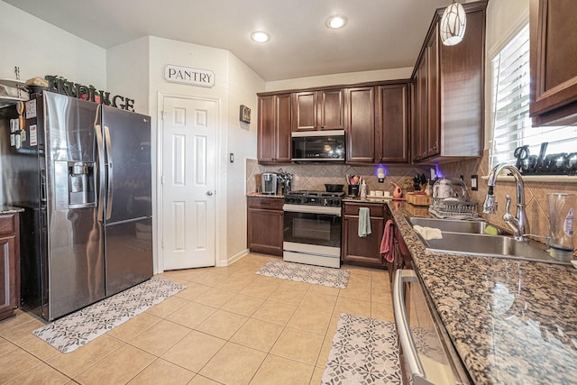 21530 Amesbury Meadow Ln, Spring, TX 77379 - kitchen with appliances with stainless steel finishes, backsplash, light tile patterned floors, dark brown cabinets, and recessed lighting