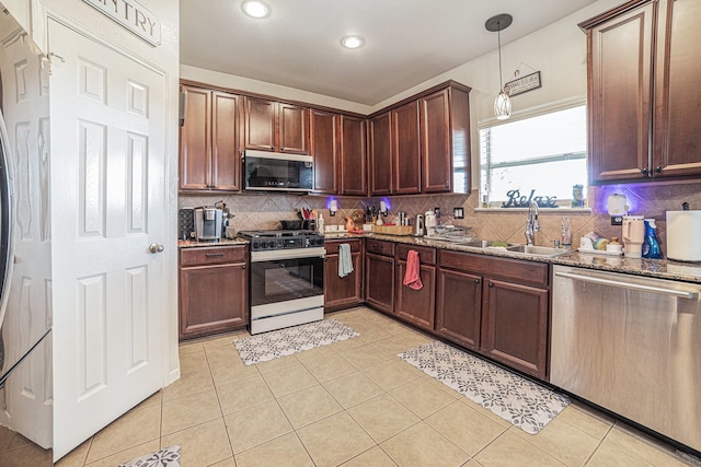 21530 Amesbury Meadow Ln, Spring, TX 77379 - kitchen featuring appliances with stainless steel finishes, dark stone countertops, tasteful backsplash, light tile patterned floors, and recessed lighting