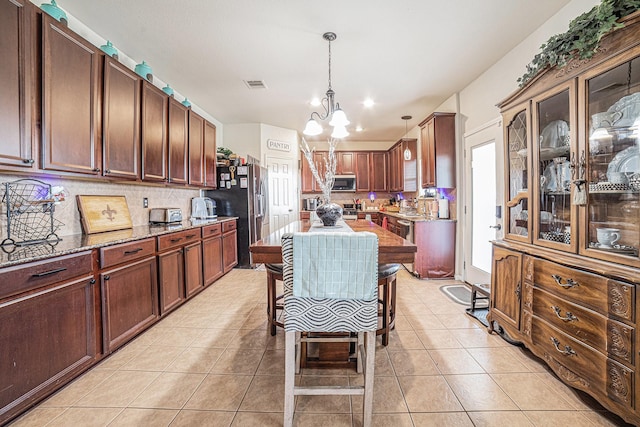 21530 Amesbury Meadow Ln, Spring, TX 77379 - kitchen with stainless steel microwave, a chandelier, decorative backsplash, fridge with ice dispenser, and recessed lighting
