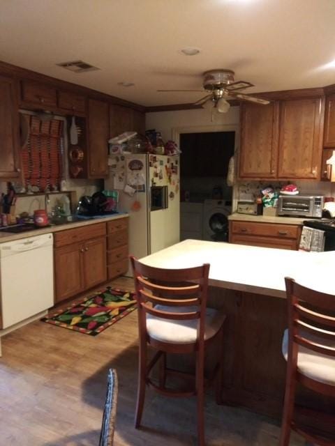 17930 N Interstate 35, West, TX 76691 - kitchen with white appliances, washer and clothes dryer, light countertops, and a kitchen bar