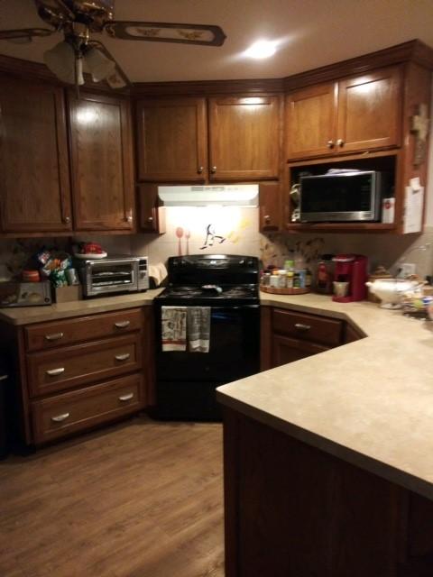 17930 N Interstate 35, West, TX 76691 - kitchen featuring electric range, stainless steel microwave, a ceiling fan, under cabinet range hood, and light countertops