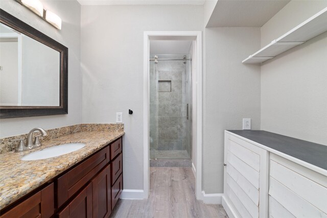 2601 S Braeswood Blvd Unit 302, Houston, TX 77025 - bathroom with vanity, a stall shower, and wood finished floors