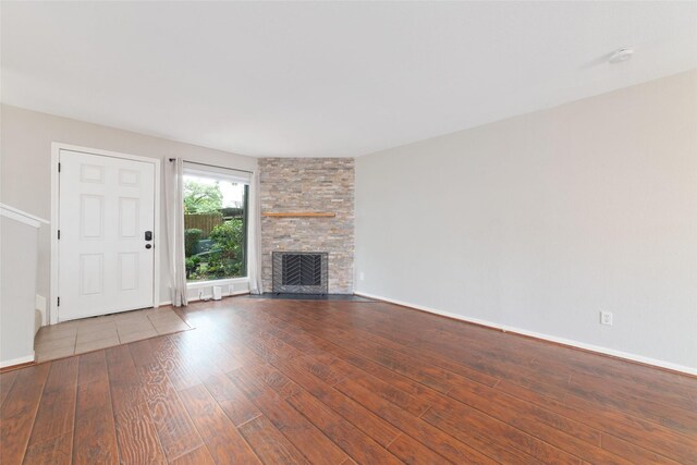 2601 S Braeswood Blvd Unit 302, Houston, TX 77025 - unfurnished living room featuring wood finished floors and a fireplace