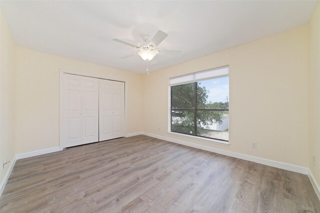 2601 S Braeswood Blvd Unit 302, Houston, TX 77025 - unfurnished bedroom with wood finished floors, a closet, and a ceiling fan