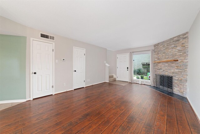 2601 S Braeswood Blvd Unit 302, Houston, TX 77025 - unfurnished living room featuring wood-type flooring, stairway, and a stone fireplace