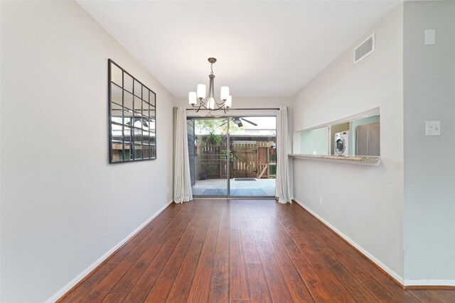 2601 S Braeswood Blvd Unit 302, Houston, TX 77025 - unfurnished dining area featuring wood-type flooring, a chandelier, and stacked washer and clothes dryer