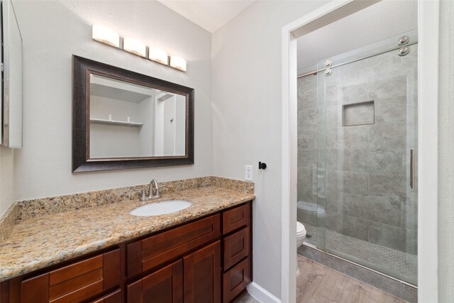 2601 S Braeswood Blvd Unit 302, Houston, TX 77025 - full bathroom with vanity, a stall shower, and wood finished floors