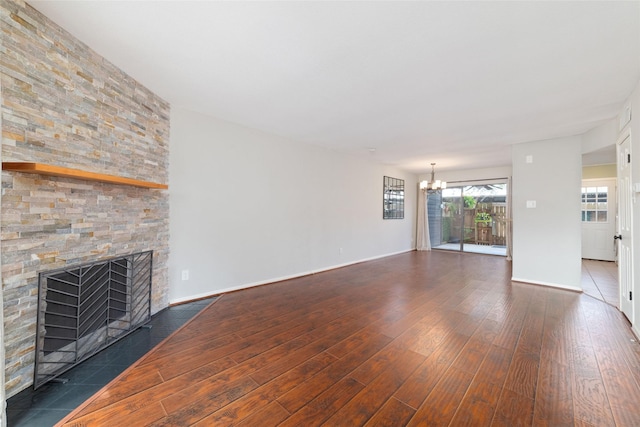 2601 S Braeswood Blvd Unit 302, Houston, TX 77025 - unfurnished living room featuring dark wood-style floors, a chandelier, and a stone fireplace
