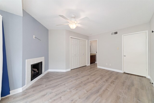 2601 S Braeswood Blvd Unit 302, Houston, TX 77025 - unfurnished living room with ceiling fan, light wood-style floors, and a fireplace
