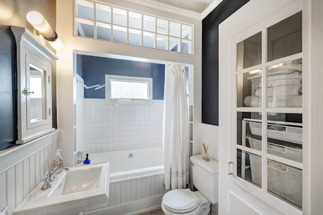 936 W Temple St, Houston, TX 77009 - bathroom with shower / tub combo, a wainscoted wall, and a decorative wall