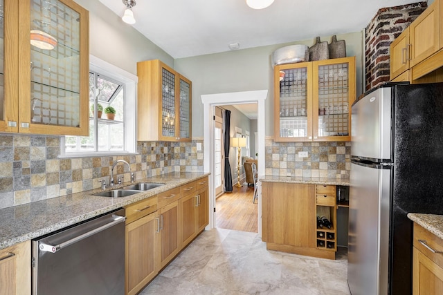 936 W Temple St, Houston, TX 77009 - kitchen with stainless steel appliances, tasteful backsplash, light stone countertops, and glass insert cabinets